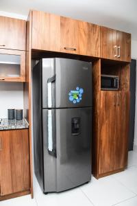 um frigorífico de aço inoxidável numa cozinha com armários de madeira em Torre Real VI em Santiago de los Caballeros