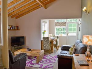 sala de estar con sofá y mesa en Magpie Cottage en Gristhorpe