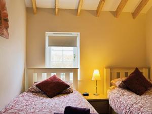 una camera con due letti e una finestra di Magpie Cottage a Gristhorpe