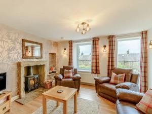 a living room with a couch and a fireplace at Kiln Hill Cottage in Pateley Bridge