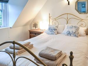 a bedroom with a large white bed with blue pillows at Oakwood Cottage in Glencoe