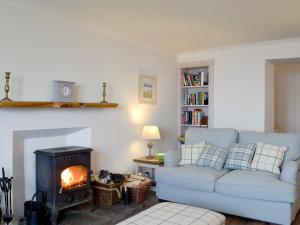 a living room with a couch and a fire place at Raglan Cottage in Ardentinny