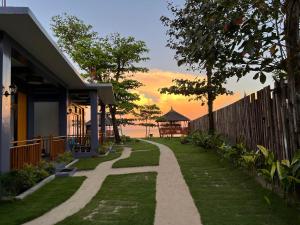 a pathway leading to a house with the ocean in the background at Takbo Beach Resort in General Luna
