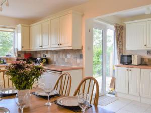 a kitchen with a table with chairs and a microwave at Penhayes View in Kenton