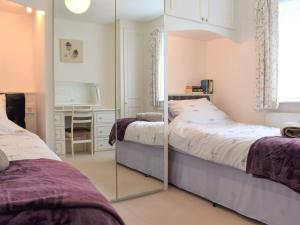 a bedroom with two beds and a mirror at Penhayes View in Kenton
