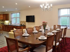 a dining room with a large wooden table and chairs at Liftingstane Farmhouse in Closeburn