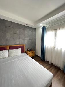Holiday Suites Hotel & Spa في هانوي: غرفة نوم بسرير كبير ونافذة