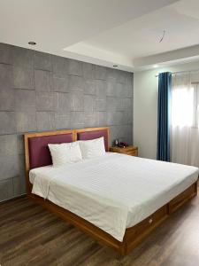 a bedroom with a large bed with white sheets at Holiday Suites Hotel & Spa in Hanoi