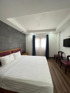 a bedroom with a large bed and a television at Holiday Suites Hotel & Spa in Hanoi