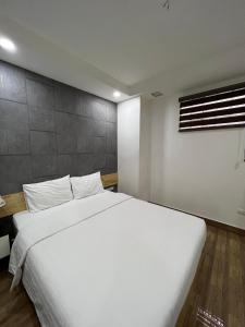 Holiday Suites Hotel & Spa في هانوي: سرير أبيض كبير في غرفة مع نافذة