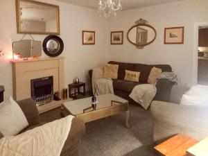The Saddlers Cottage في East Boldon: غرفة معيشة مع أريكة ومدفأة