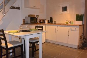 Appart´choisille في La Membrolle-sur-Choisille: مطبخ مع طاولة وكراسي وميكروويف