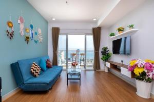 un salon avec un canapé bleu et une table dans l'établissement Nice Oasky with seaView Apartment Vũng Tàu, à Vung Tau