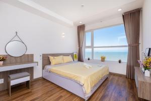 une chambre avec un lit et une grande fenêtre dans l'établissement Nice Oasky with seaView Apartment Vũng Tàu, à Vung Tau 67 autres photos