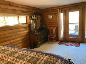 1 dormitorio con 1 cama y pared de madera en Hummingbird Hill Resort: Hot Tub, Views, Wildlife, 3D movies, Hiking, Bikes, Sleds, Games, Kids & Pets Love It en Naches