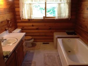 a bathroom with a tub and a toilet and a sink at Hummingbird Hill Resort: Hot Tub, Views, Wildlife, 3D movies, Hiking, Bikes, Sleds, Games, Kids & Pets Love It in Naches