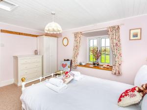 a bedroom with a white bed and a window at The Farmhouse - Uk33419 in West Witton