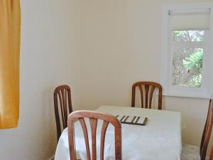 a table and chairs with a white table and a window at Ardmore in Largs