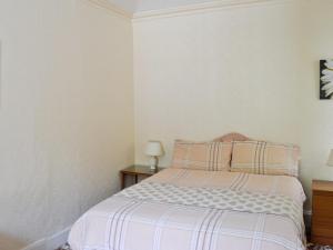 a bedroom with a bed with pink and white stripes at Ardmore in Largs