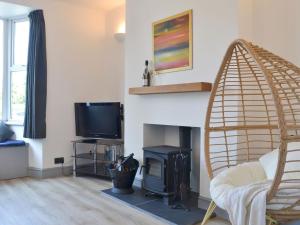 a living room with a fireplace and a tv at Railway Terrace in Malvern Wells