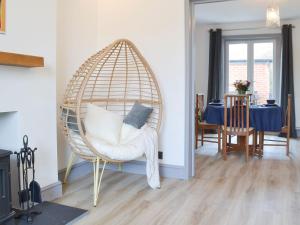 a room with a rattan chair with a table and a dining room at Railway Terrace in Malvern Wells