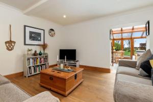 a living room with a couch and a coffee table at Trellys Hyfryd - cottage in Fishguard