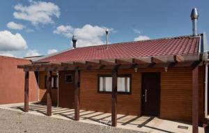 una pequeña casa de madera con techo rojo en Casa do Guiga en São Joaquim