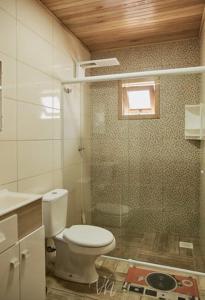 baño con aseo y ducha y ventana en Casa do Guiga, en São Joaquim