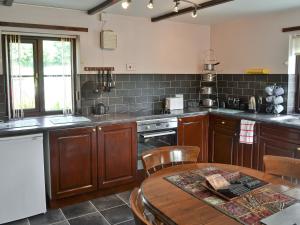 a kitchen with wooden cabinets and a wooden table with a tableablish at Rallt Fawr in Gwalchmai