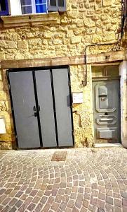 two doors on a stone building with a brick sidewalk at *Le Namasté*Fibre Wifi*Hyper Centre* in Salon-de-Provence