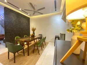 ein Esszimmer mit einem Tisch und grünen Stühlen in der Unterkunft Luxury 2-Storey Terrace House near IOI City Mall Putrajaya in Putrajaya