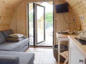 a living room with a couch and a sliding glass door at Pentland Pod in Penicuik