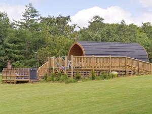a large wooden barn with a black roof at Pentland Pod in Penicuik