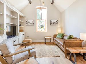 a living room with a couch and a tv at The Old Workshop in Broom