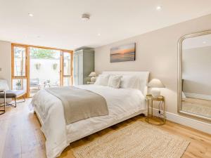 a bedroom with a large white bed and a large window at The Old Workshop in Broom