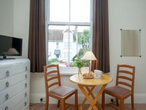 a dining room table with two chairs and a window at Apartment One - Uk39832 in Paignton