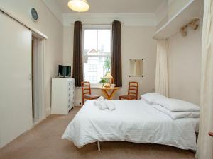 a bedroom with a bed and a desk and a window at Apartment One - Uk39832 in Paignton