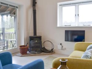 una sala de estar con estufa de leña. en Staveley Park Studio - Uk33716, en Staveley