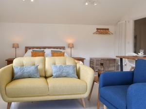 a living room with a yellow couch and a bed at Staveley Park Studio - Uk33716 in Staveley
