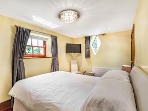 a bedroom with a white bed and a window at Corby Castle - Diamond Cottage - Uk34668 in Great Corby