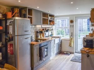 a kitchen with a stainless steel refrigerator and a sink at Warrington House in Tideswell