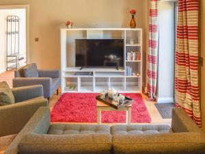 a living room with a couch and a tv at Beckside House in Dalton in Furness