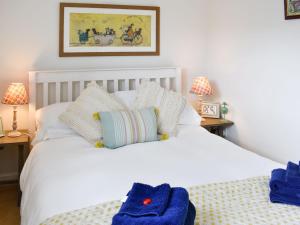 ein Schlafzimmer mit einem weißen Bett und blauen Handtüchern darauf in der Unterkunft Number 3 - Uk33333 in Newby