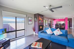 a living room with a blue couch and a view of the ocean at Birdland in Port Fairy