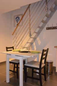 stół jadalny z 2 krzesłami i schody w obiekcie Appart´choisille w mieście La Membrolle-sur-Choisille