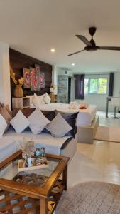 uma sala de estar com 2 camas e uma mesa de vidro em Chaweng Beautiful Studio. em Koh Samui