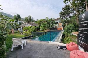 a swimming pool with a chair and a house at Chaweng Beautiful Studio. in Koh Samui