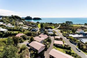 an aerial view of a village with the ocean in the background at Unit 7 Kaiteri Apartments and Holiday Homes in Kaiteriteri