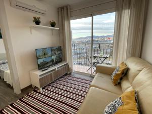 a living room with a couch and a large window at Magnifico Apartamento Barca 4 in Sant Adria de Besos