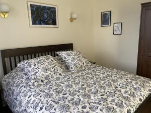 ein Bett mit einer schwarzen und weißen Bettdecke und Kissen in der Unterkunft Magnifique T3 au centre, jardin privatif, proche thermes, wifi, parking, jeux extérieurs, lave-linge/sèche-linge - FR-1-541-94 in La Roche-Posay + 4 Fotos